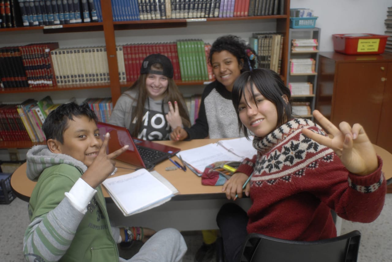 Estudiantes trabajan juntos en una mesa de la biblioteca
