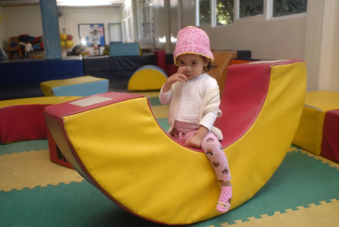 Niña pequeña sube a un juego de espuma en su salón
